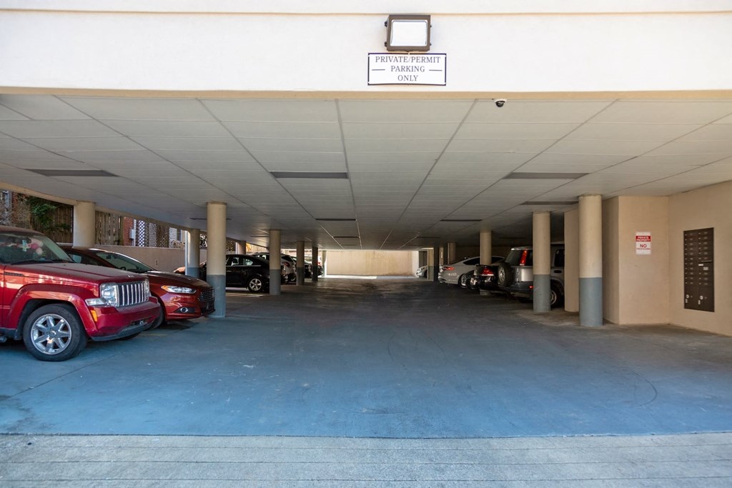 State Street Flats Apartments parking garage located on street level. Large parking garage with "private permit parking only" sign.