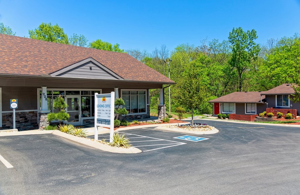 The Retreat at Indian Lake in Hendersonville leasing office exterior with parking lot and next door apartment building surrounded by green trees.