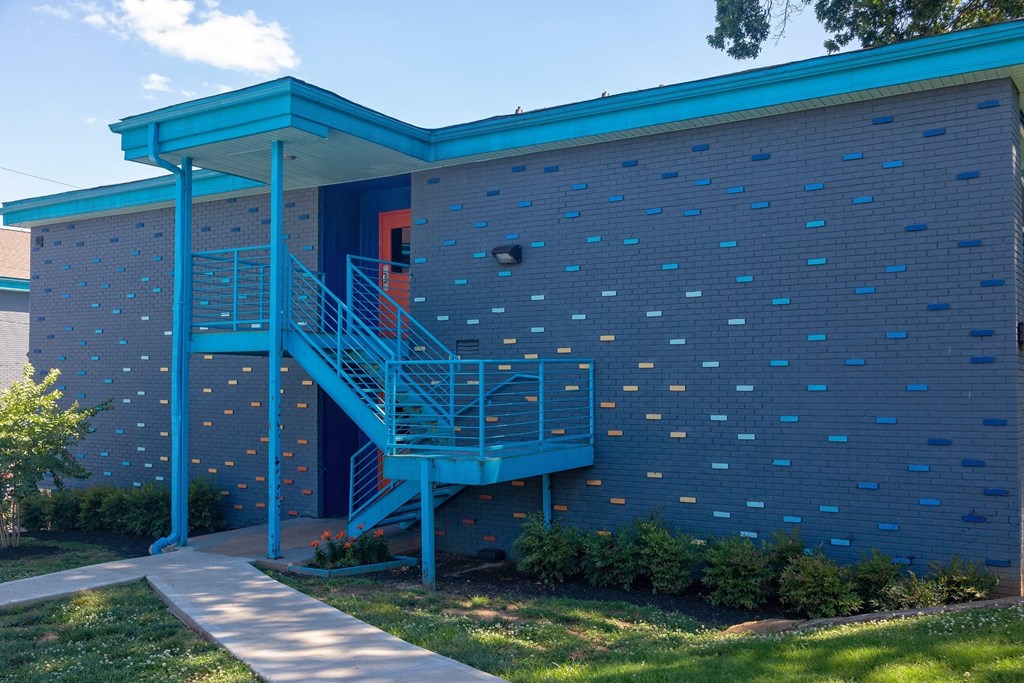 The Canvas apartments in Nashville, Tennessee exterior. Two story building is blue brick with reflective rainbow accent bricks.