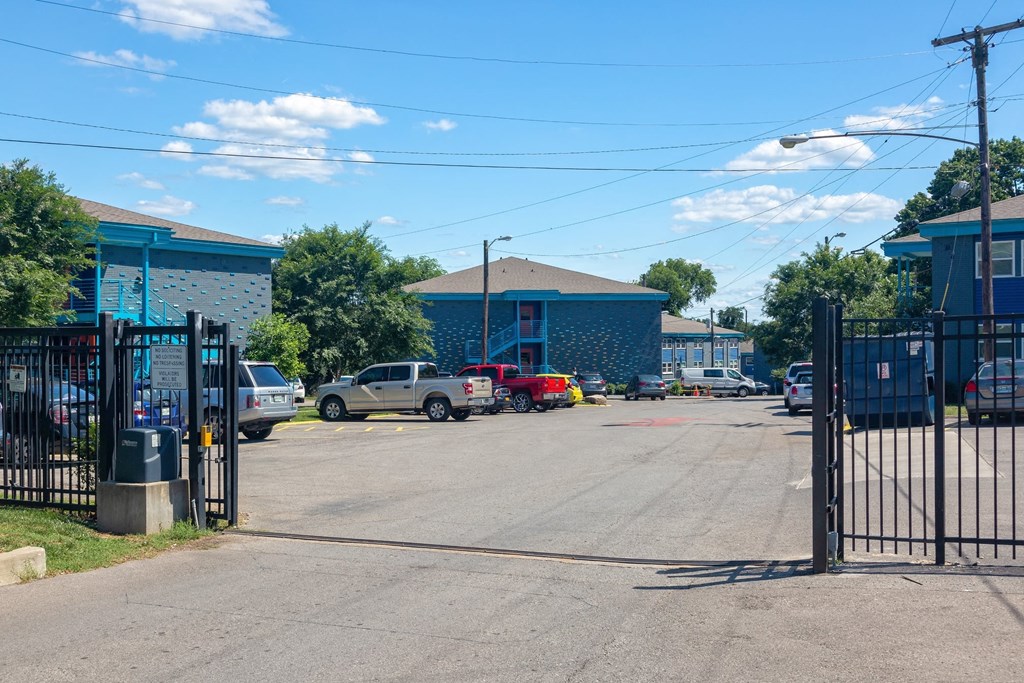 The Canvas apartments in Nashville, Tennessee on-site gated parking lot with metal mechanized gate and facility dumpsters.