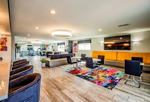 A modern living room with a variety of seating options and a colorful rug.