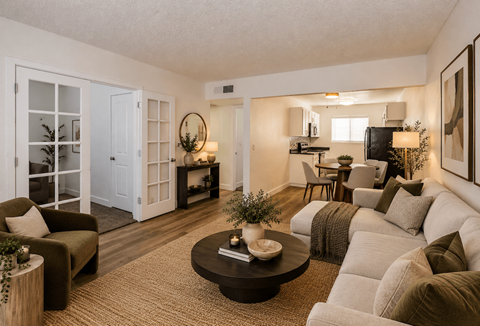 Fifteen 50 Apartments living room staged with a white couch, a coffee table, and a television.