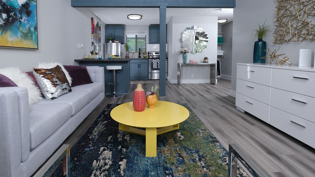 Fusion Las Vegas apartments view from living room to kitchen. Living room has colorful modern decor and kitchen has navy blue accents.