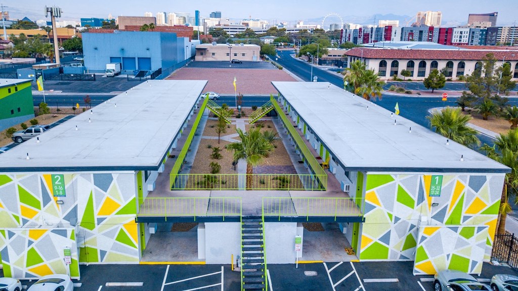 Aerial view of Fusion Las Vegas apartment building with green, yellow, and grey geometric painted walls and lime green railing