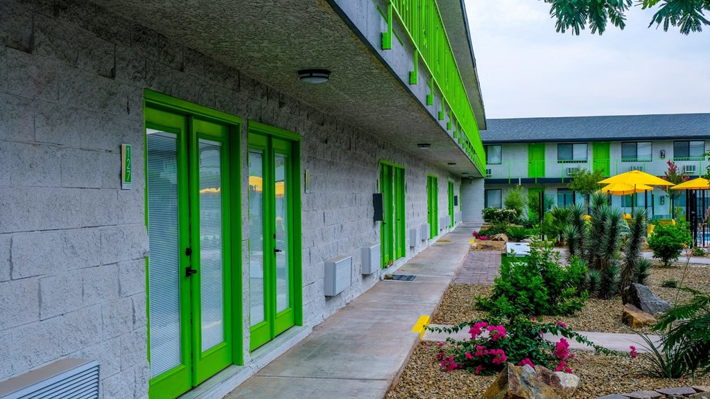 Fusion Las Vegas apartment building interior courtyard with blooming desert landscaping and lime green railing on second story.