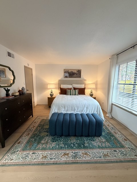 Fusion Crossroads bedroom with a bed, dresser, and mirror.