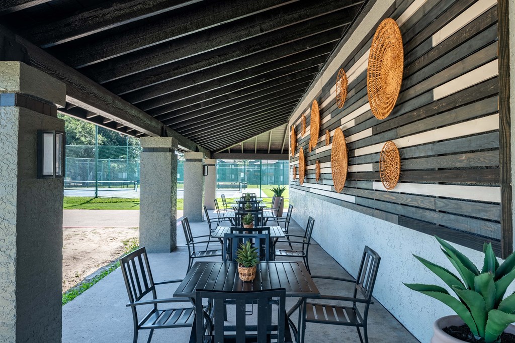 a patio with tables and chairs outside of a building