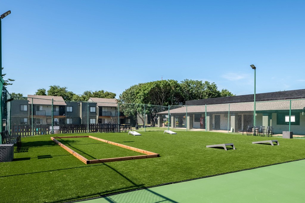 recreation lawn at fusion Fort Worth apartments in Haltom City, TX with corn hole and patio furniture