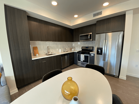 A modern kitchen with a table and chairs in the foreground.