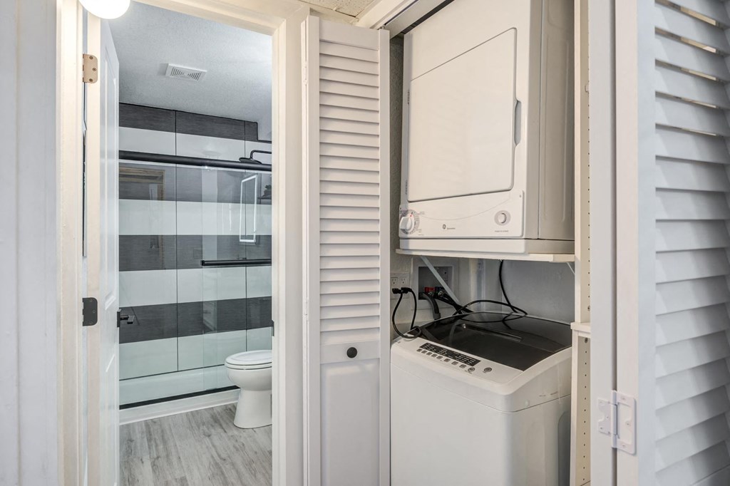 Fusion Warner Center apartments in Woodland Hills in-unit laundry with top load washer and front load dryer in closet with shutter doors.