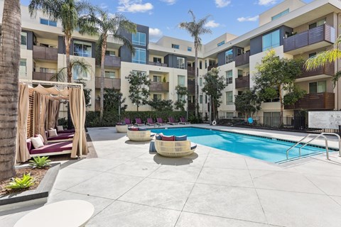 Fusion Encore Hollywood Apartments pool area with a building in the background.