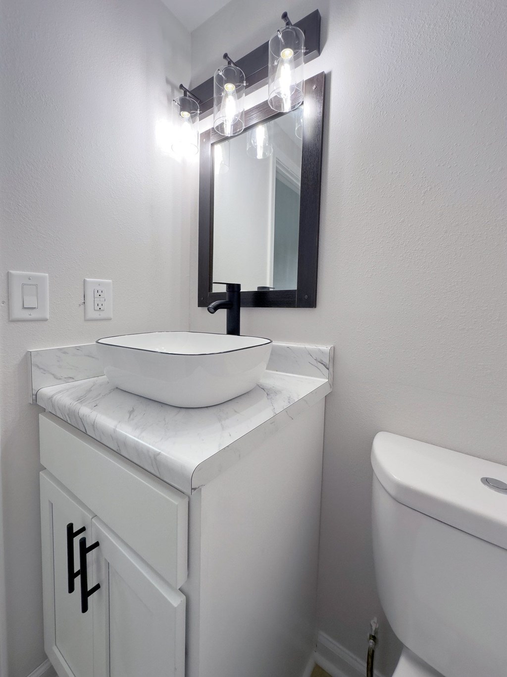 Retreat at Indian Lake apartments in Hendersonville, TN white bathroom vanity with a marble top and a mirror above it.