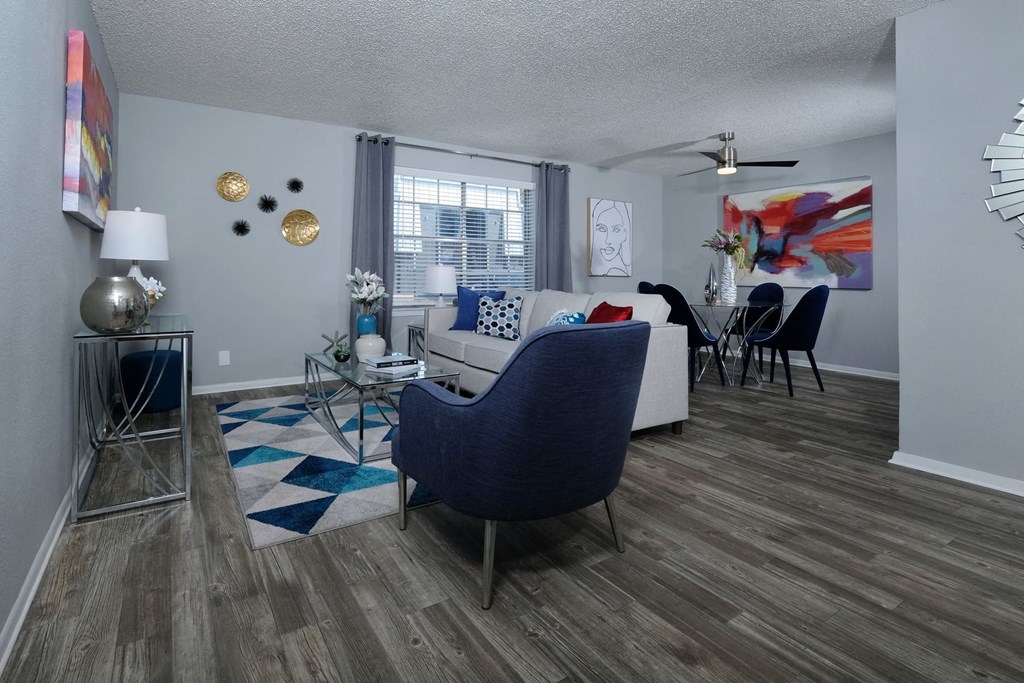 Living room and dining area in Stadium 700 apartments in Arlington  tx with modern furniture, luxury plank flooring, and large window.