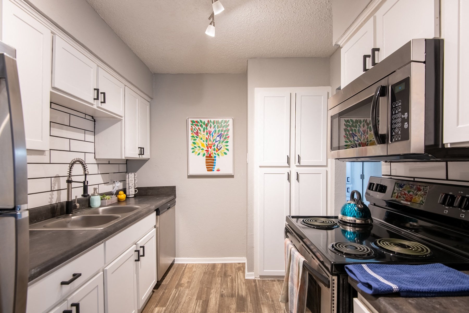 Apartments Arlington, TX spacious galley kitchen in Stadium 700 luxury apartments with stainless steel appliances and white cabinets