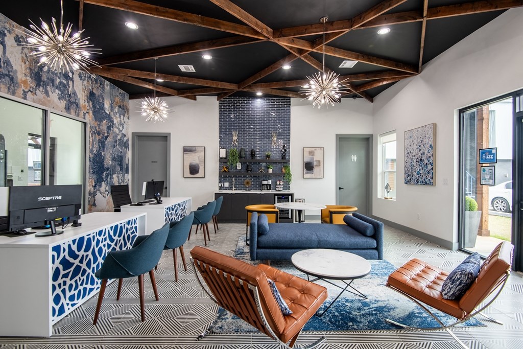 Leasing office at Stadium 700 apartments in Arlington, TX with comfortable seating, large desks, and coffee bar