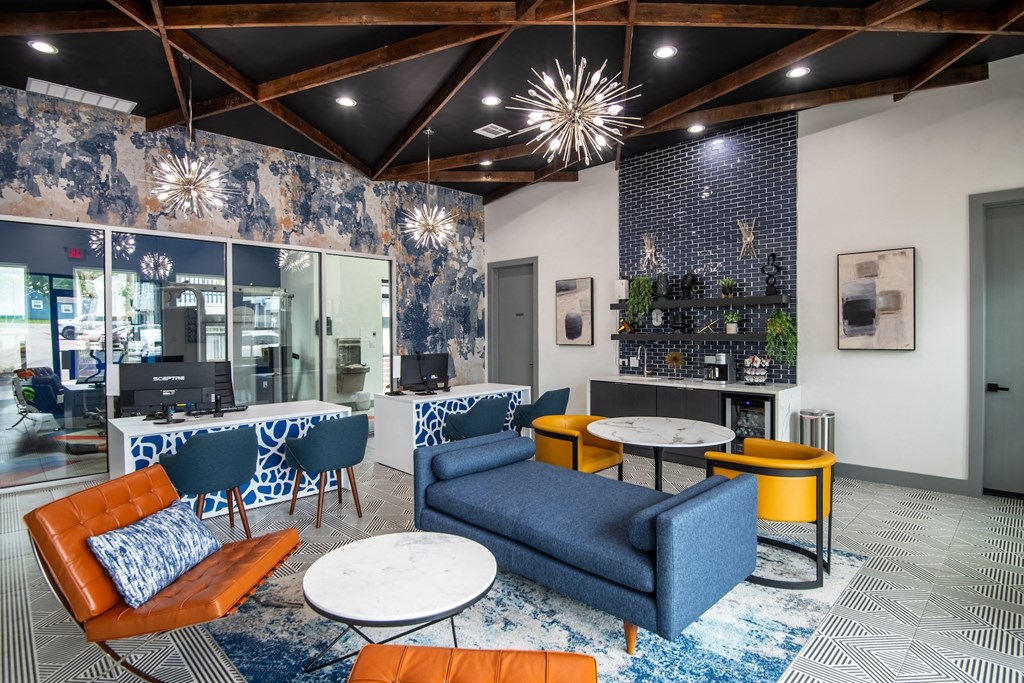Inside leasing center at Stadium 700 Apartments in Arlington, TX with mid-century seating and a large leasing desk