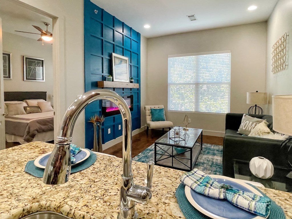 Interior of one bedroom apartment in the State Street Flats in Nashville. Living area is open concept and has a blue accent wall.
