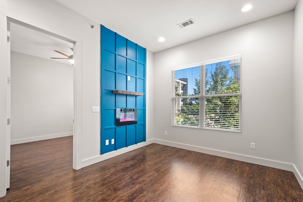 State Street Flats 1 bedroom apartments Nashville TN living room with a blue wall and wooden floors.