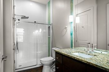 A bathroom with a toilet, sink, and shower.