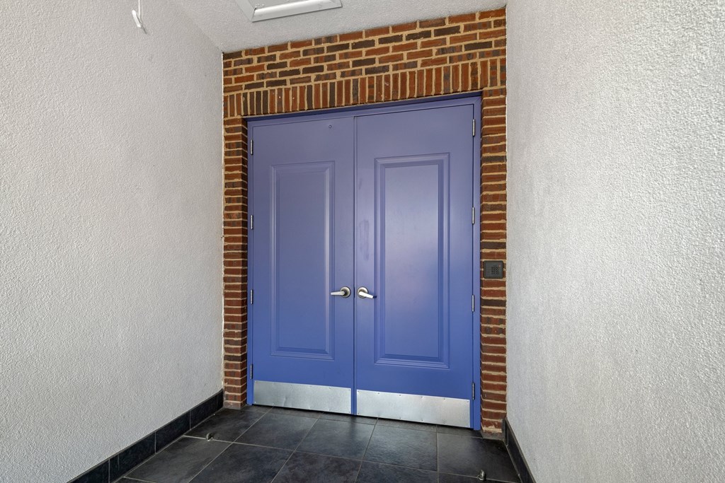 State Street Flats in Nashville blue door is in a room with a brick wall.