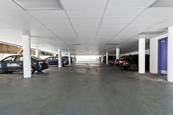 A parking garage with cars parked on both sides.