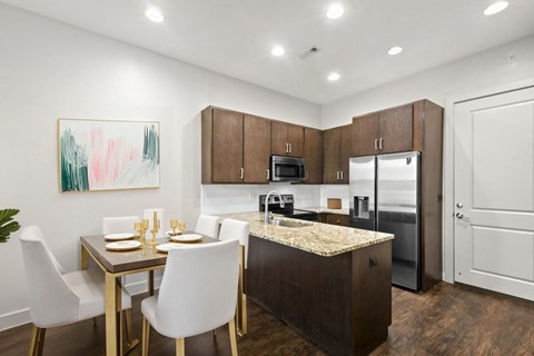 A modern kitchen with a dining table set for two.