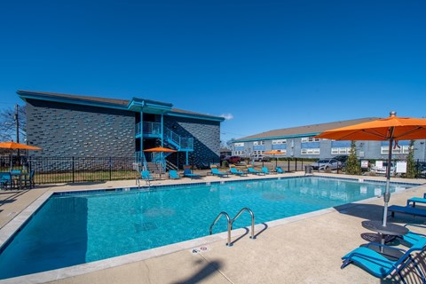 The Canvas Apartments Nashville swimming pool with a blue tiled building in the background.