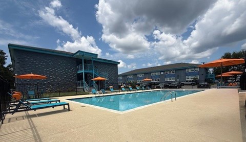 The Canvas Nashville swimming pool area with sun loungers and a building in the background.
