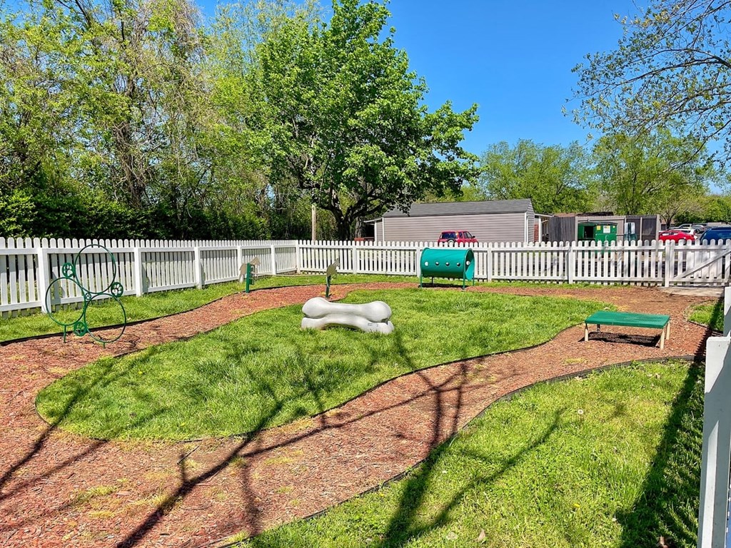 Pet park at the Retreat at Indian Lake apartments in hendersonville with dog agility course on brown mulch track surrounded by green grass.