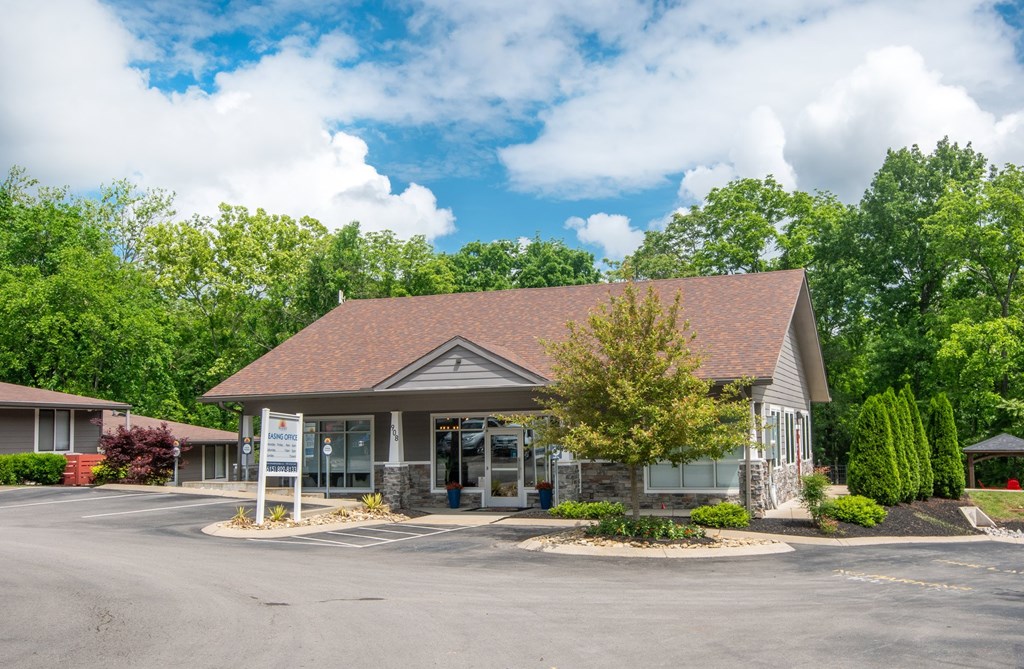 The Retreat at Indian Lake leasing office with a brown roof and a parking lot in front.