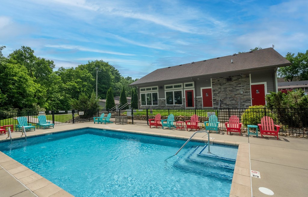 Retreat at Indian Lake Apartments Hendersonville TN swimming pool with red chairs and a building in the background.
