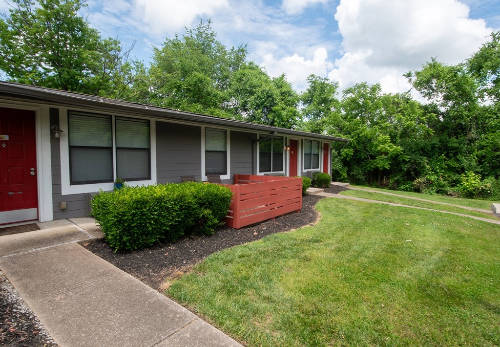 A red door is on the left side of a grey building at The Retreat at Indian Lake Apartments in Hendersonville TN.