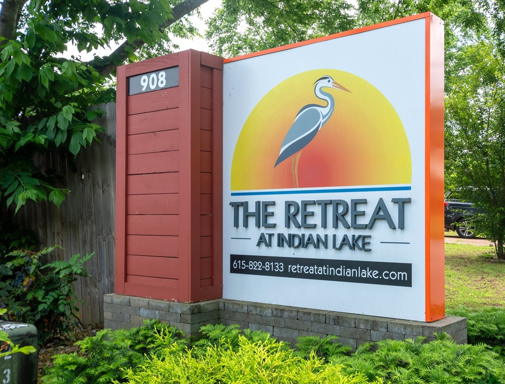 Monument sign for The Retreat at Indian Lake Apartments with a crane on it.