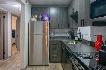 Nashville Apartments - The Canvas - Modern Kitchen with Soft-Close Wood-Inspired Cabinets, Stainless-Steel Appliances, and Hardwood-Inspired Flooring - Photo Gallery 7