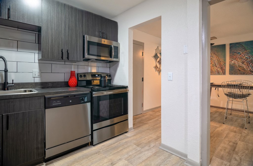 Kitchen in the Canvas Apartments in Nashville with modern grey wood cabinets and stainless steel dishwasher, microwave, and electric stove.