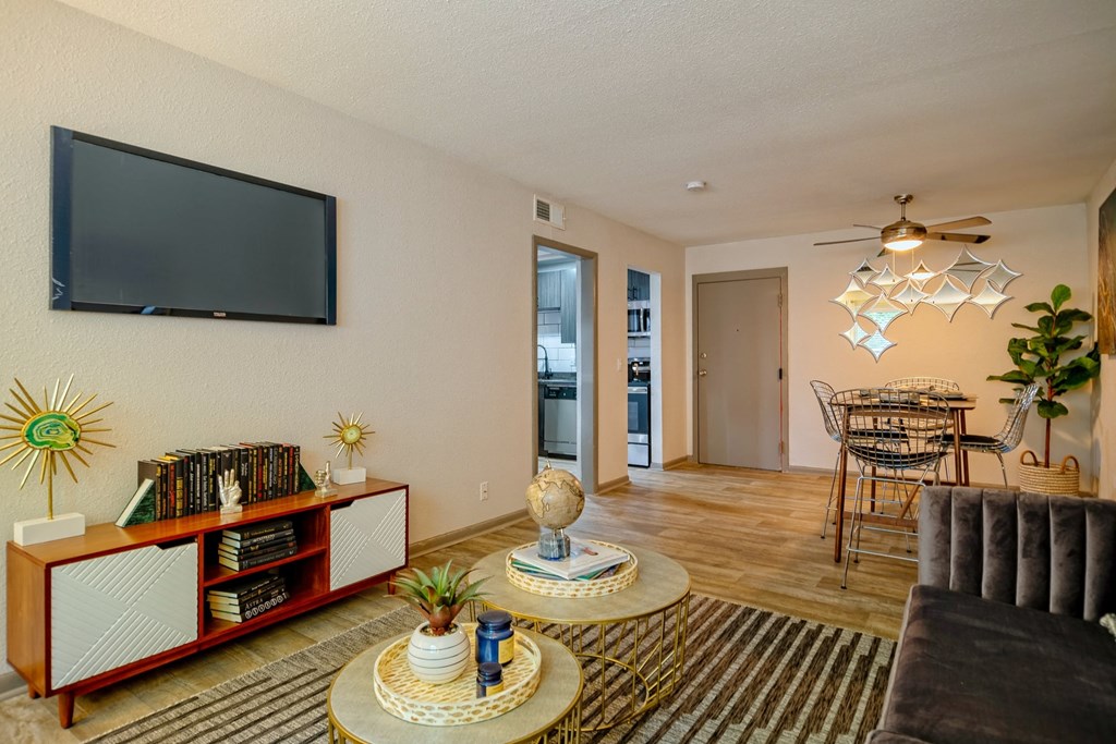 Open concept Living room in the Canvas Apartments in Nashville and dining room with two archways into kitchen and luxury wood style floors.