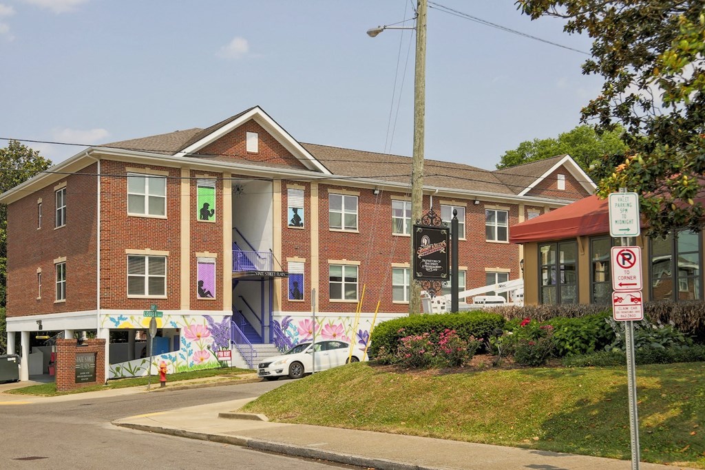 Street view of State Street Flats apartment building in downtown Nashville. Building is a large brick building on the street corner.
