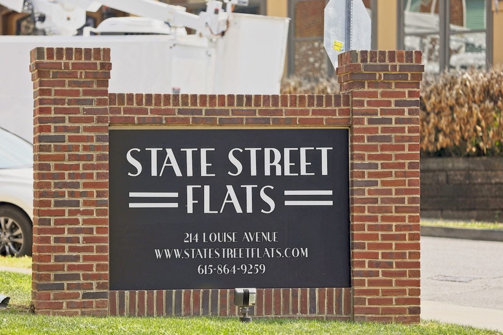 Brick Monument sign on Louise Ave in Nashville, TN that reads, "State Street Flats" surrounded by green grass.