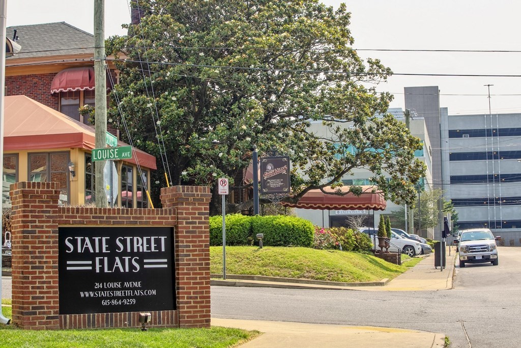 Brick Monument sign on Louise Ave corner in Nashville, TN that reads, "State Street Flats" with trees and buildings in background.