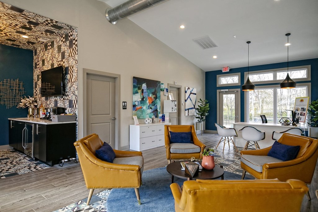 The Retreat at Indian Lake apartments lobby in hendersonville with midcentury modern seating area and coffee corner with TV.