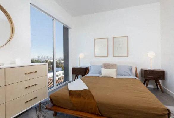 A bedroom with a large bed and a dresser.