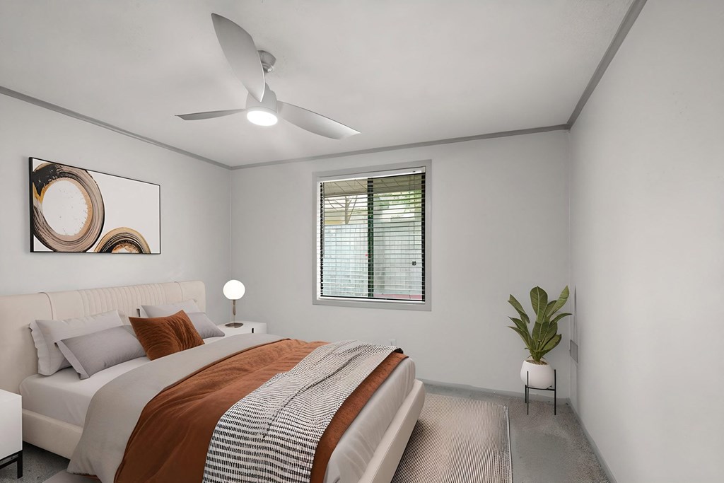 Retreat at Indian Lake Hendersonville TN apartments bedroom with a bed, a ceiling fan, and a plant.