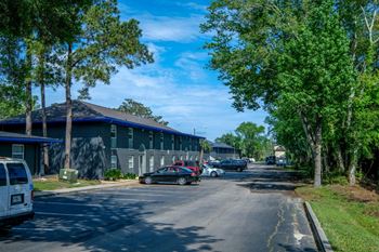 off-street parking at mandarin bay apartments in Jacksonville, CA with large trees and two-story apartment buildings.