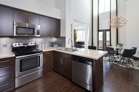 A modern kitchen with dark wood cabinets and stainless steel appliances.