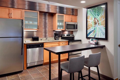 A kitchen with a refrigerator, oven, microwave, and dishwasher.