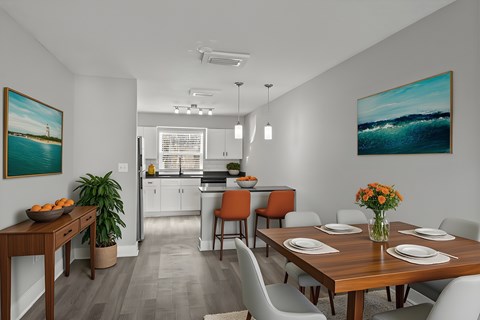 A dining room with a wooden table set for four at Mandarin Bay Apartments.