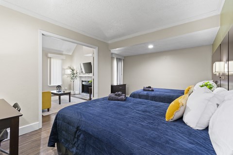 Fusion Orlando furnished bedroom with two large beds and an opening to the living room.