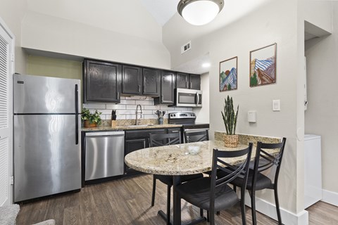 A kitchen with a table and chairs at Fusion Orlando Furnished Apartments.