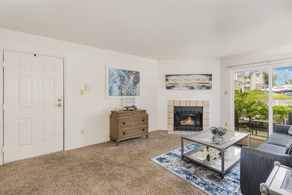 A living room with a fireplace and a painting on the wall.