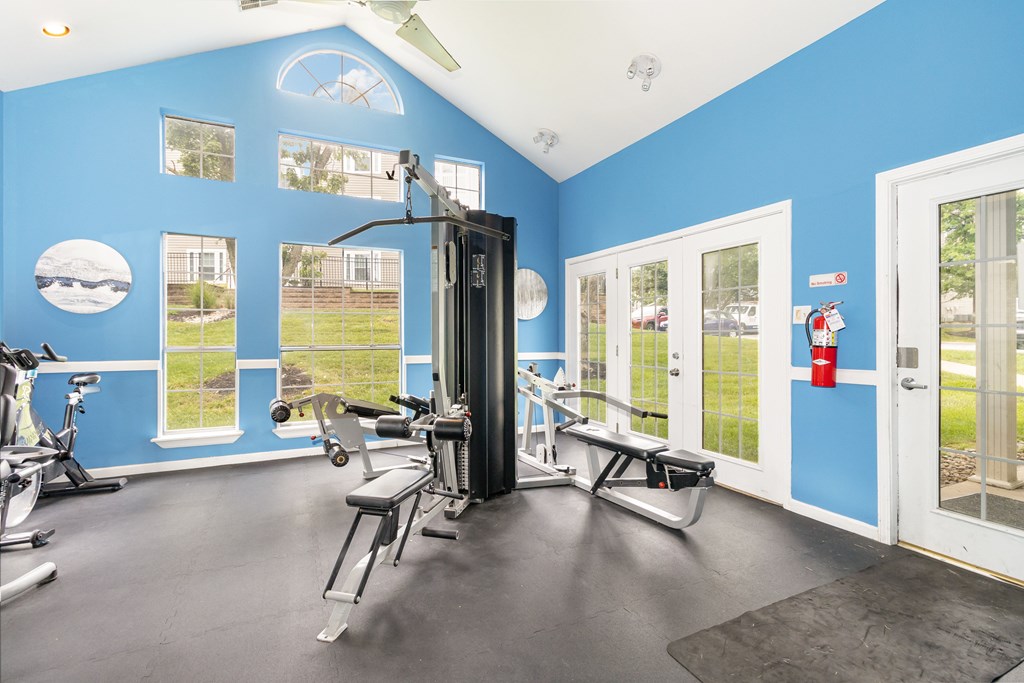 A gym with a variety of equipment including a treadmill, exercise bike, and weight machine.
